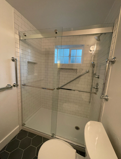 White basement bathroom remodel with a corner shower