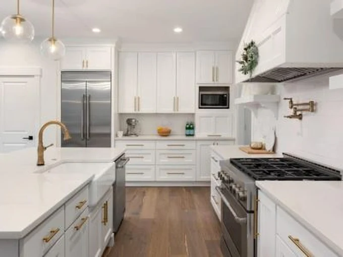 White‑themed kitchen remodel with a sink and updated lighting installed